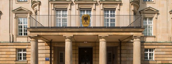 Sandsteinfarbenes Eingangsportal mit Säulen und Bundesfinanzhof-Wappen