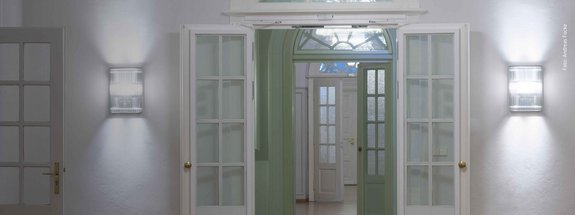 geöffnete weiße Holzflügeltüren mit Flurlichtern im Art-déco-Stil im Bundesfinanzhof