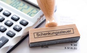 Calculator and next to it a stamp with gift tax printed on it