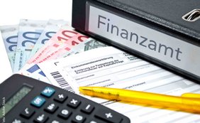 Ordner mit Aufschrift Finanzamt, Taschenrechner, Geldscheine, Kugelschreiber